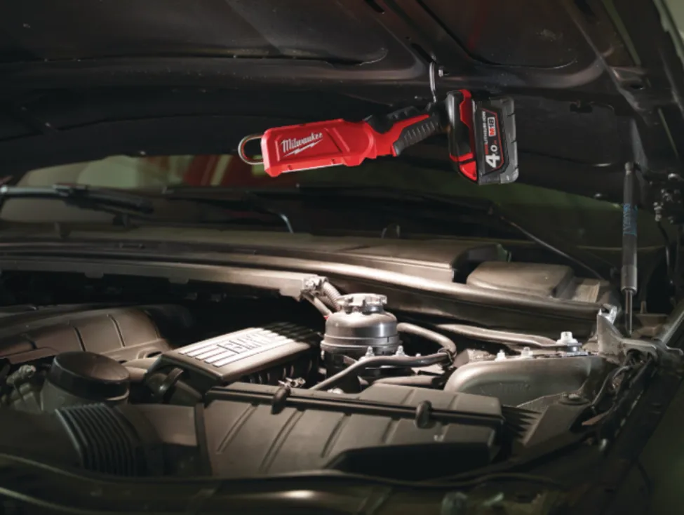 Milwaukee cordless LED underhood work light providing bright illumination over a car engine, showcasing leading brand alternatives to SurfPrep.