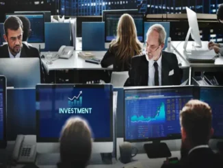 Financial traders working at desktop monitors displaying stock charts, data graphs, and an investment icon in a modern trading floor office.