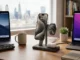A modern 3-in-1 wireless charging station on a wooden desk charging an iPhone, Apple Watch, and AirPods simultaneously in a bright office space.