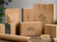 An assortment of custom kraft boxes, bags, and pouches featuring natural and organic branding labels on a wooden table.