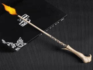 A replica Elder Wand shooting a small flame from its tip, resting on a black box.