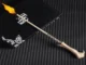A replica Elder Wand shooting a small flame from its tip, resting on a black box.