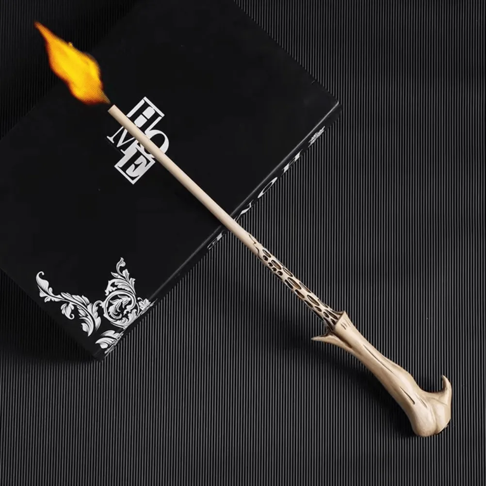 Voldemort replica Harry Potter wand shooting a bright yellow flame from its tip, resting on a black book