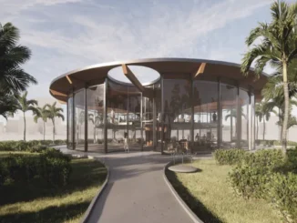 A modern circular glass pavilion designed by an architect, featuring floor-to-ceiling windows and tropical palm tree landscaping.