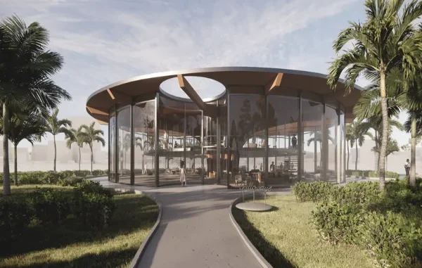 A modern circular glass pavilion designed by an architect, featuring floor-to-ceiling windows and tropical palm tree landscaping.