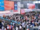 Crowds of attendees gathering at the entrance gates and registration area of the SIAL global food and beverage exhibition.