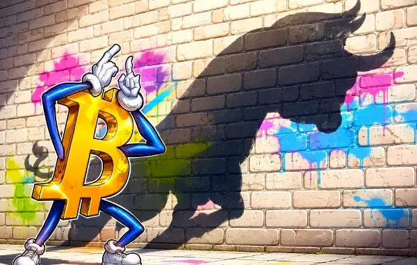 A cartoon Bitcoin mascot standing in front of a brick wall, casting a large bullish market shadow.