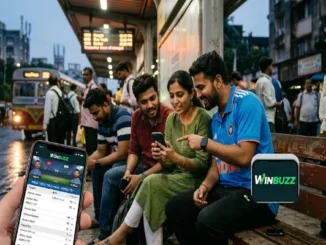 A close-up of a hand holding a smartphone displaying live cricket scores on the Winbuzz app, with a group of friends checking updates at a bus stop in the background.