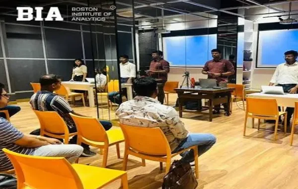 A group of students in an interactive classroom setting at Boston Institute of Analytics in Hyderabad, where one student is presenting to the class while others listen and take notes, symbolizing practical training and placement preparation.