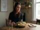 A woman in recovery eating a healthy salmon and vegetable whole food meal to support gut health and mental stabilization.