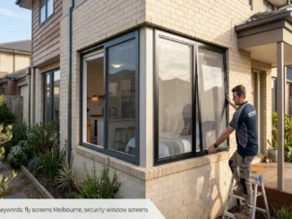 A technician fitting a black frame security window screen on a modern Melbourne home's ground-floor brick window.