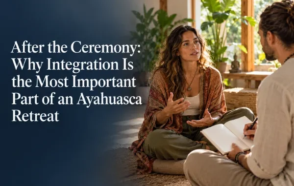 A woman sitting cross-legged during a post-ceremony integration session, speaking with a guide who is taking notes in a notebook.