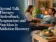 A man attached to biofeedback monitoring equipment reclines during a holistic addiction recovery session with a practitioner, with a fresh healthy salad bowl in the foreground.