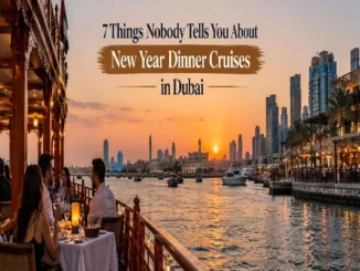 Guests dining on a traditional wooden dhow cruise in Dubai during a vibrant sunset with the city skyline in the background.