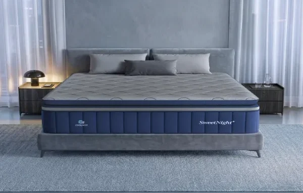 A modern bedroom setup featuring a SweetNight Coolnest cooling mattress with quilted grey top and navy blue side panels on a grey upholstered bed frame.