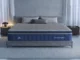 A modern bedroom setup featuring a SweetNight Coolnest cooling mattress with quilted grey top and navy blue side panels on a grey upholstered bed frame.