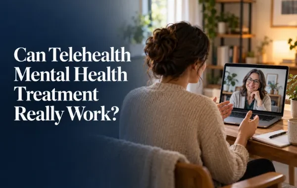 A woman sitting at a cozy desk at home, having a video therapy session on her laptop with a smiling mental health counselor.